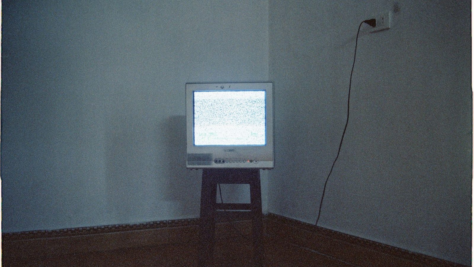 CRT screen glowing in a dark room, photographed in grainy zine monochrome